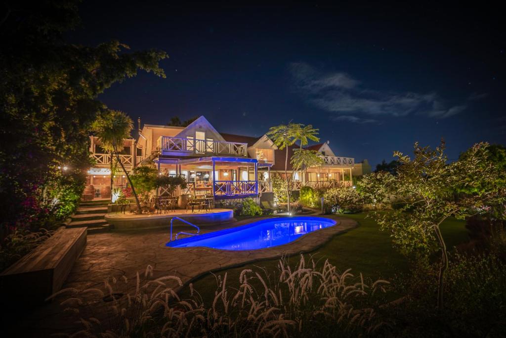 a house with a swimming pool at night at YEBO Boutique Guesthouse in Somerset West