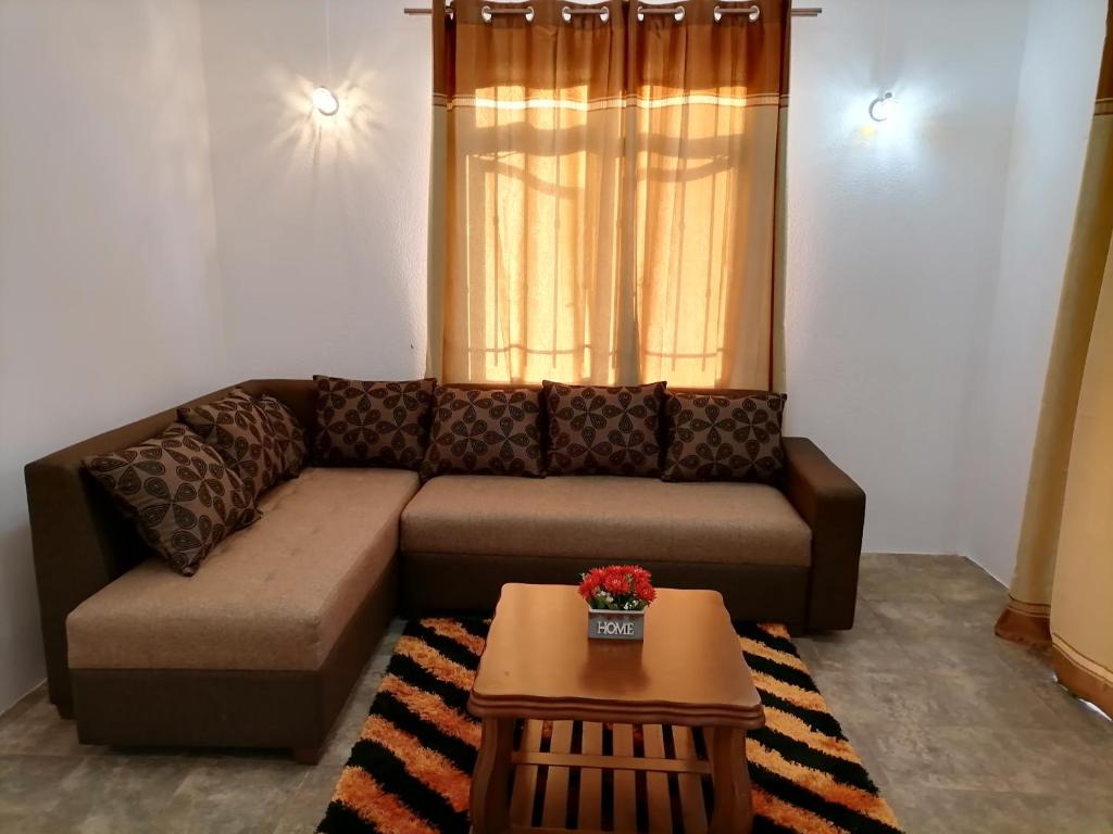a living room with a couch and a table at Khushi's Guest House - Cascavelle in Rivière Noire