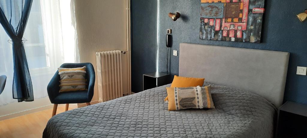 ein Schlafzimmer mit einem Bett und einem Stuhl in der Unterkunft Le Gue de Genes in Ambrieres Les Vallees
