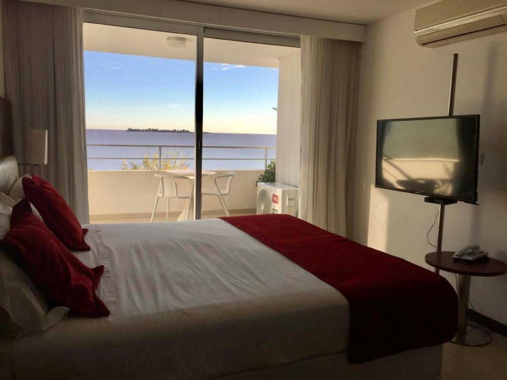 a bedroom with a bed and a view of the ocean at Golden Hour Studio - Dos Orillas 404 in Colonia del Sacramento