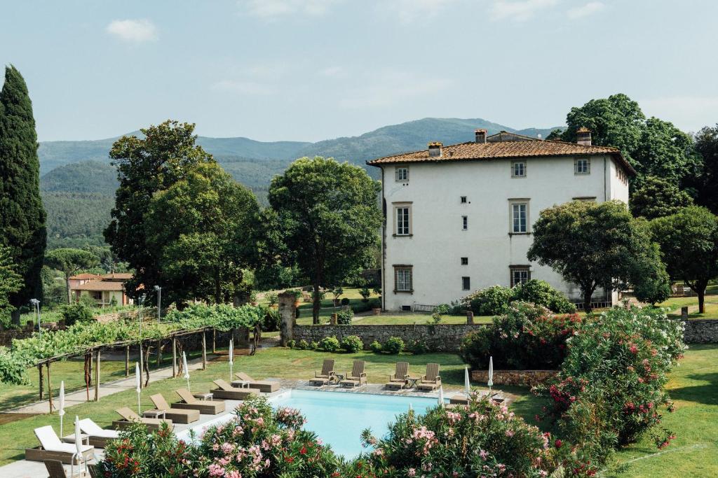 a villa with a swimming pool in front of a building at Buonvisi B&B in Lucca