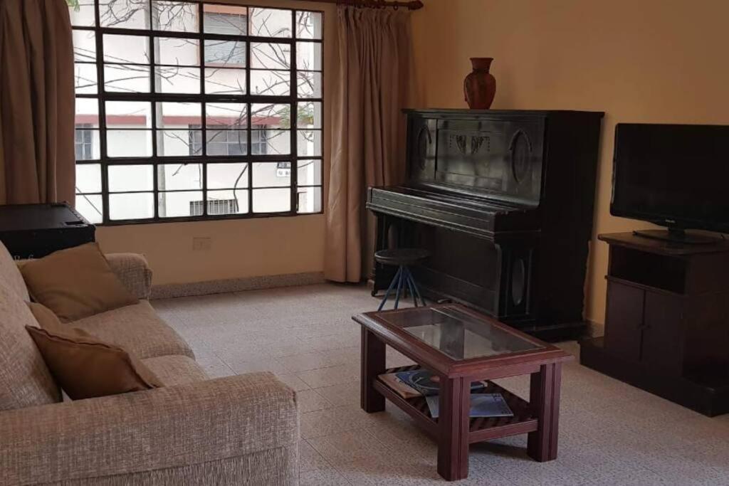 een woonkamer met een piano en een salontafel bij Tu Lugar en Tucumán in San Miguel de Tucumán