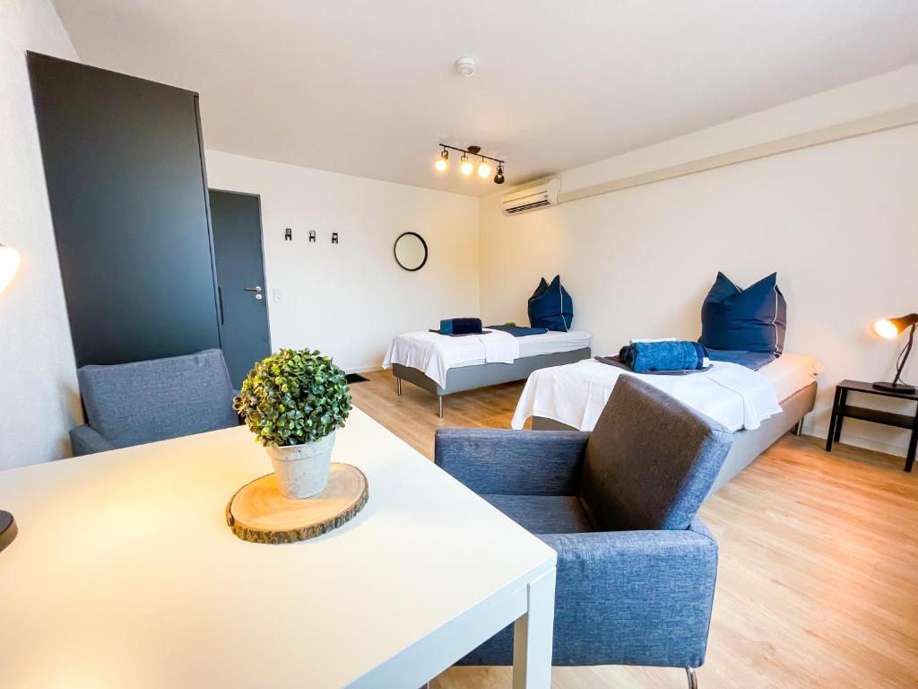 um quarto com duas camas, um sofá e uma mesa em Hegau Boardinghouse em Singen