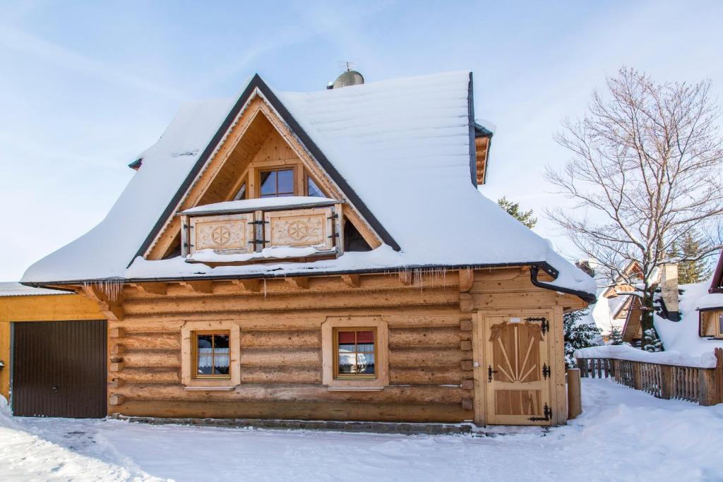 uma cabana de madeira com um telhado coberto de neve em Domek Jawor em Zakopane