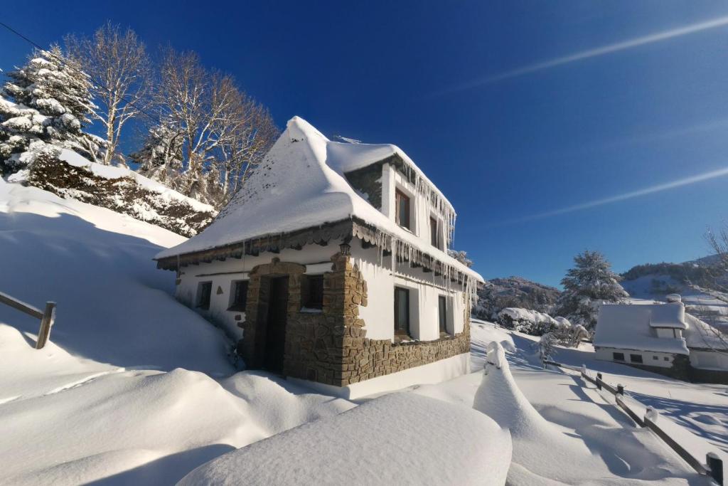 a building covered in snow in the snow at Chalet avec vue panoramique sur le Plomb du Cantal in Saint-Jacques-des-Blats