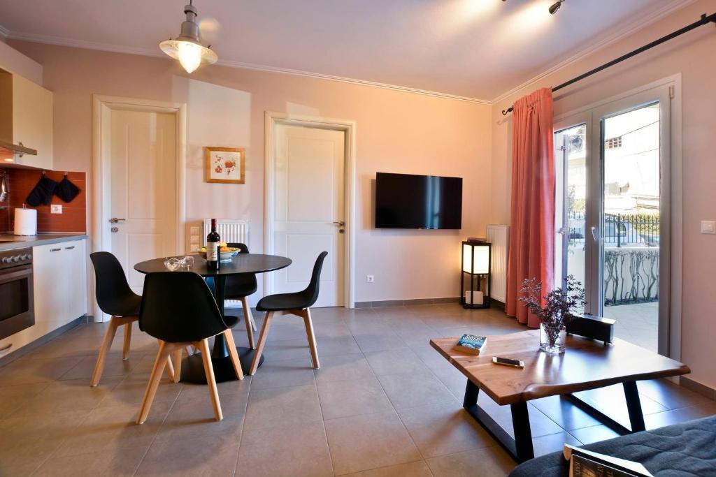 a living room with a table and chairs and a kitchen at Mon Repos Apartments in Corfu Town