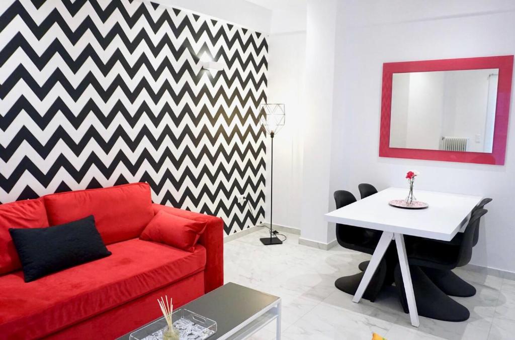 uma sala de estar com um sofá vermelho e uma mesa em Cozy apartment in the center of Athens em Atenas