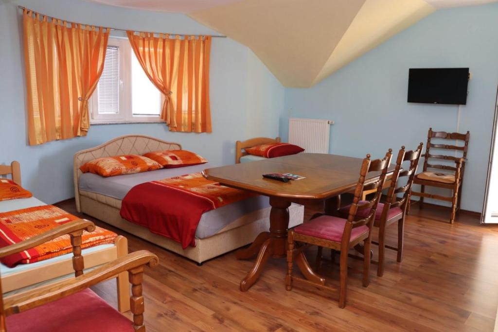 Rooms & Apartment Jozić في Prozor: غرفة نوم بسرير وطاولة وكراسي