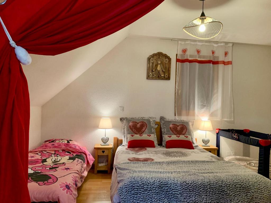 a bedroom with two beds and red curtains at LE BALCON DU GOLF in Giez