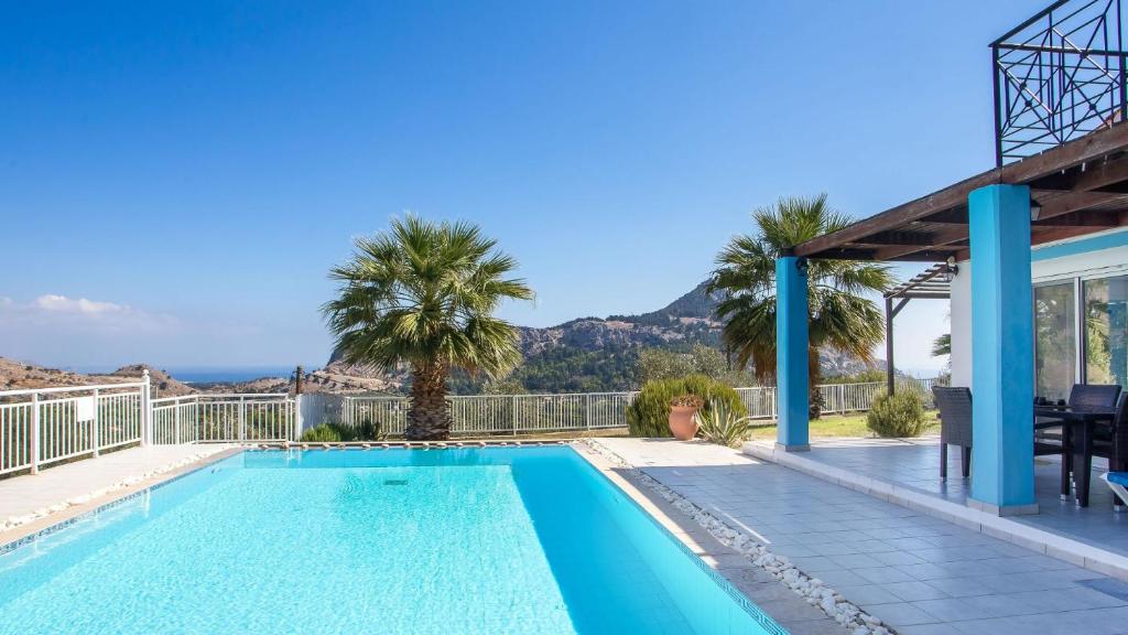 una piscina en una villa con una montaña en el fondo en Villa Selene, en Archangelos