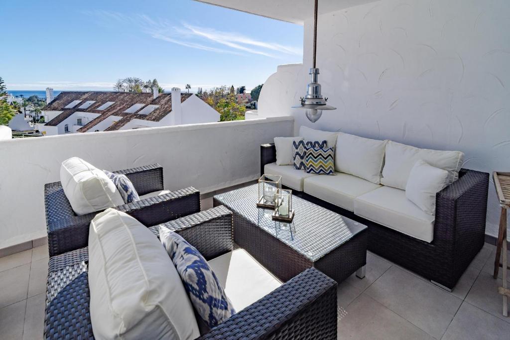 patio con sofá y mesa en el balcón en ELD1-Stunning 2 Bedroom Penthouse in Puerto B, en Marbella