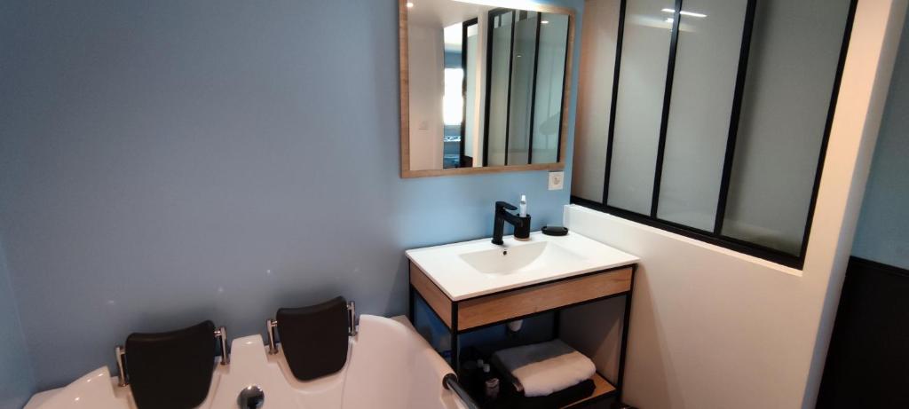 ein Badezimmer mit einer Badewanne, einem Waschbecken und einem Spiegel in der Unterkunft HOME HOSE in Monistrol-sur-Loire