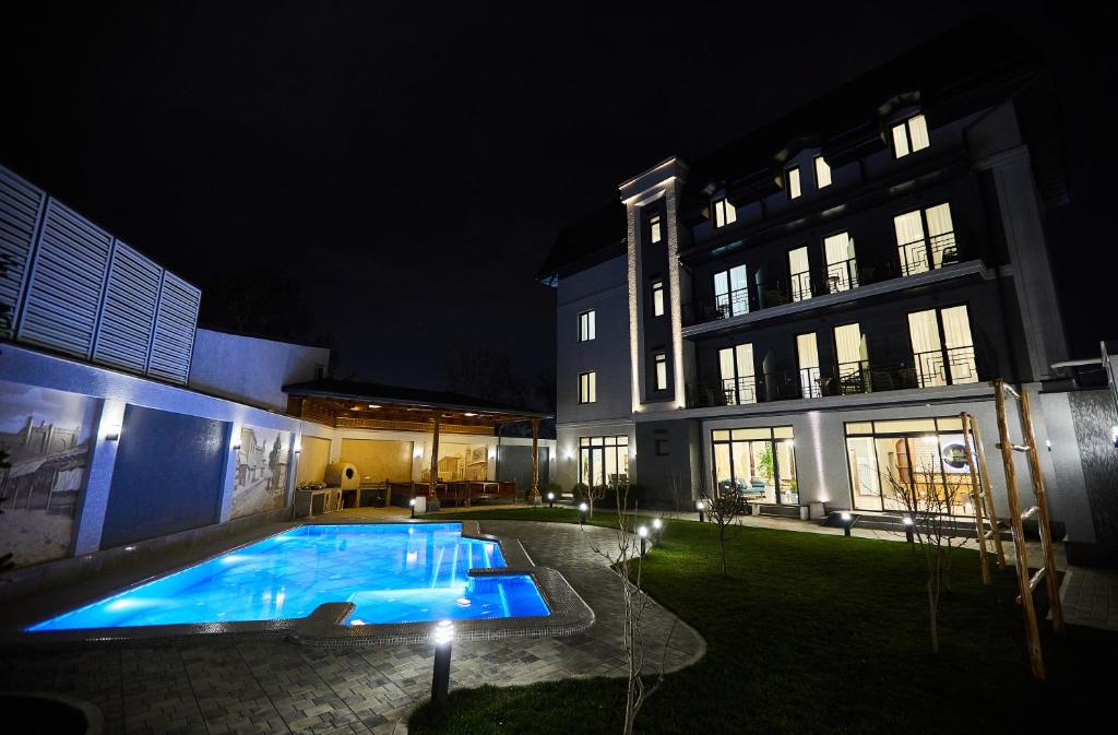 a swimming pool in the yard of a building at night at OLD TASHKENT Hotel & Spa in Tashkent