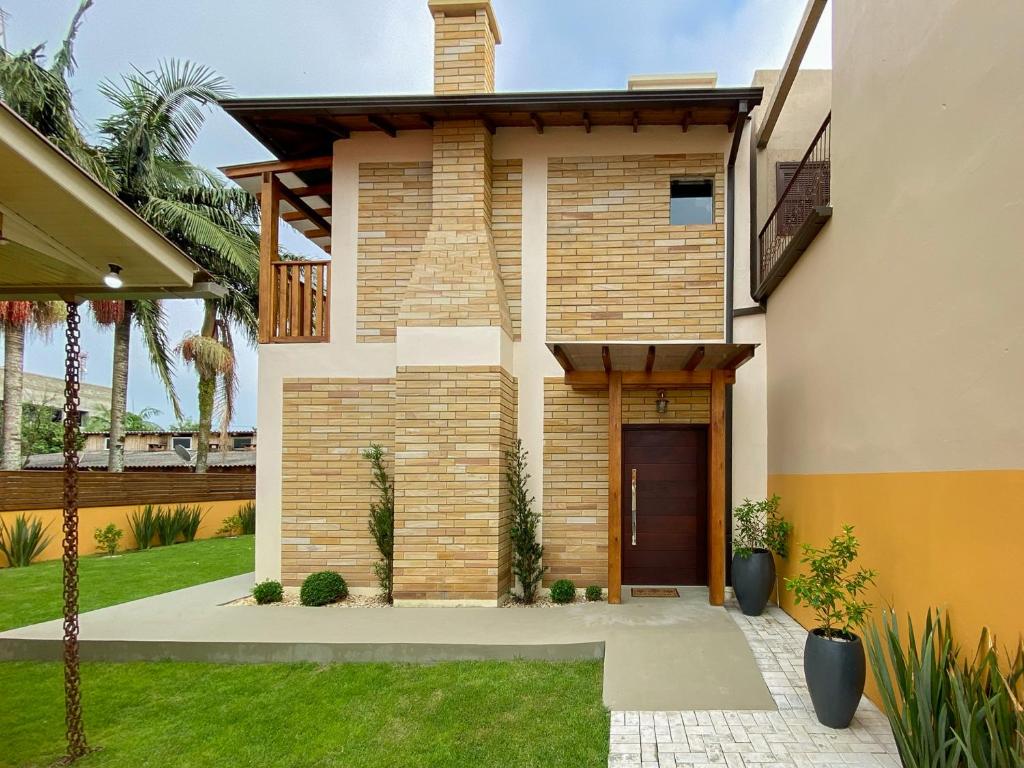 una casa con una porta d'ingresso e un cortile di Manaca House a Praia Grande