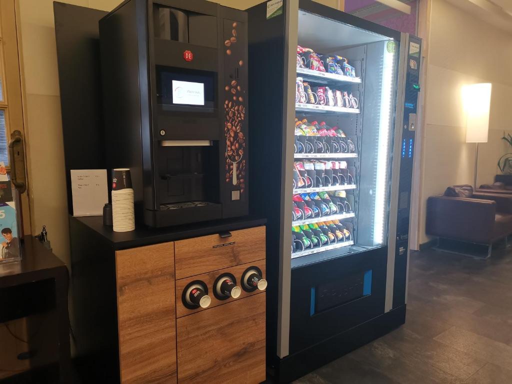 a refrigerator with a drink dispenser next to a drink at Hotel Albert II Oostende in Ostend