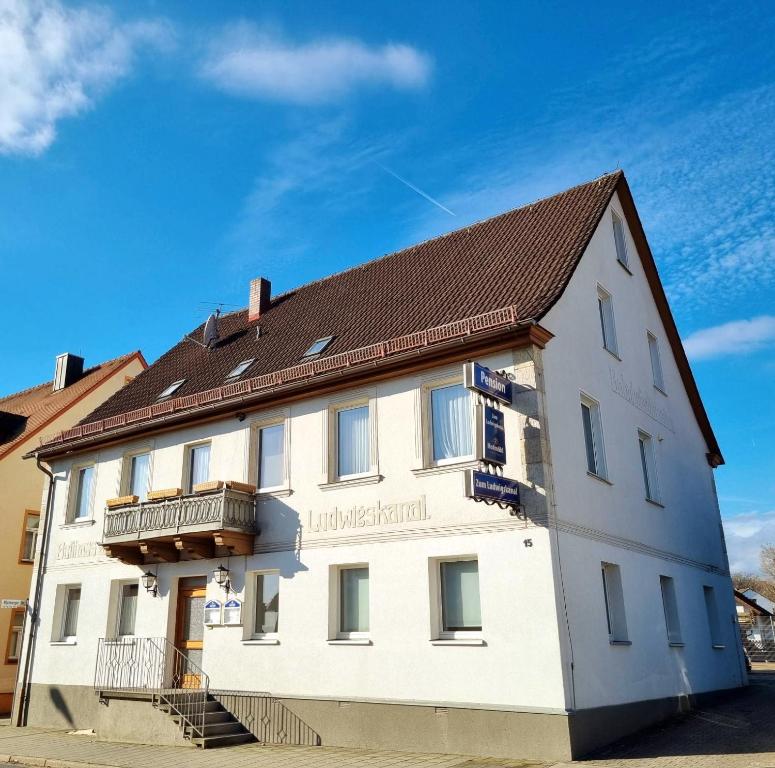 ein großes weißes Gebäude mit braunem Dach in der Unterkunft Monteurunterkunft Ludwigskanal in Wendelstein