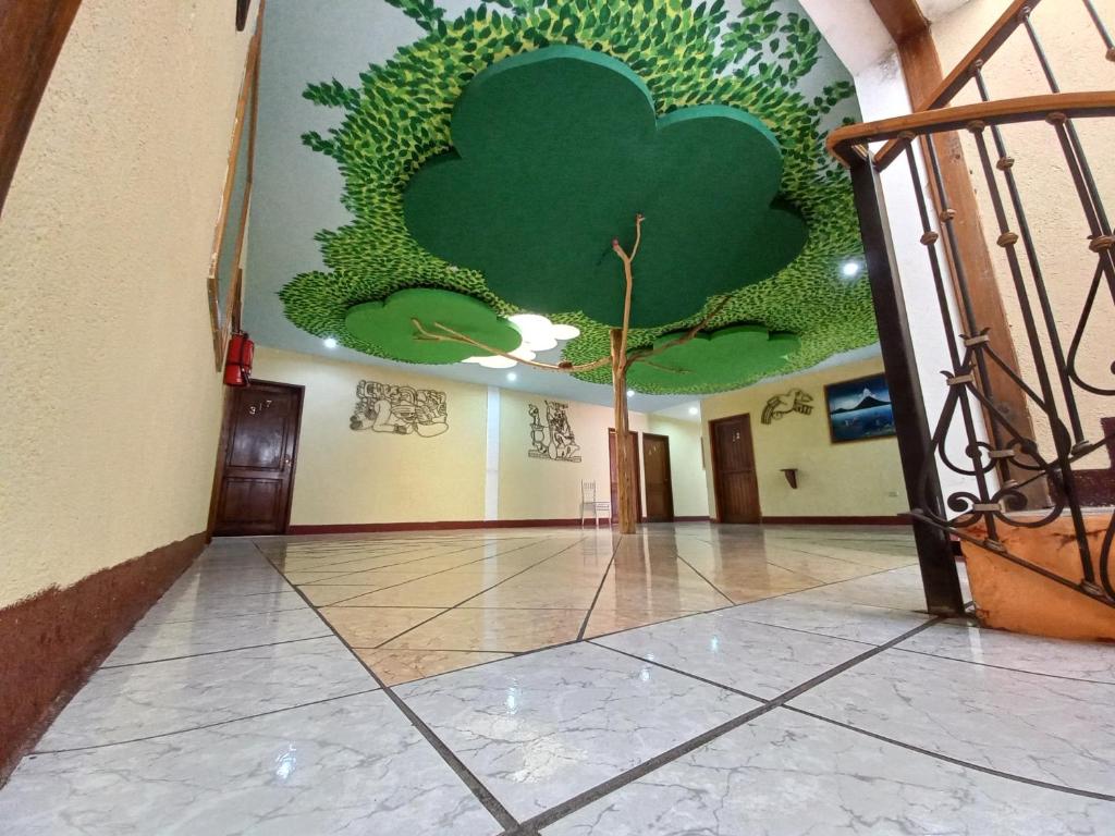 a hallway with a mural of a tree on the wall at Hotel Nakbé Atitlán in Panajachel
