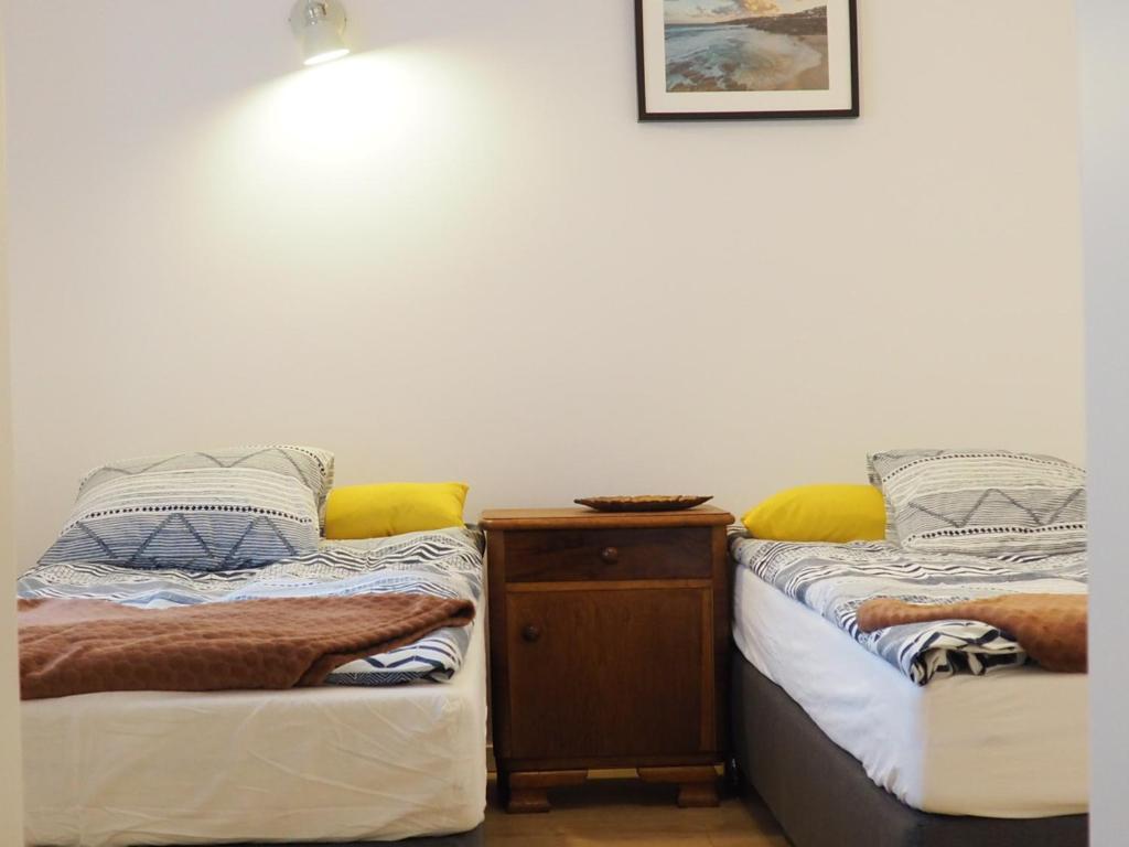 dos camas sentadas una al lado de la otra en una habitación en Apartament Zamkowa, en Puck