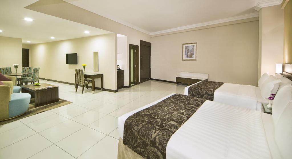 a hotel room with a bed and a living room at Gateway Hotel in Dubai