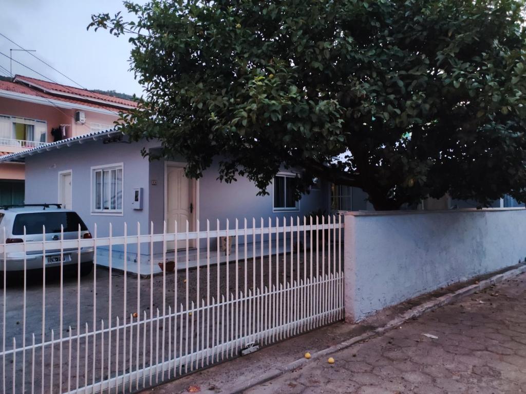 una cerca blanca frente a una casa en Casa de temporada Marlete, en Florianópolis