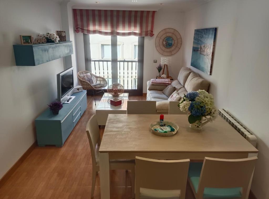 - un salon avec une table et un canapé dans l'établissement maravilloso apartamento en la playa...muy especial, à Sanxenxo