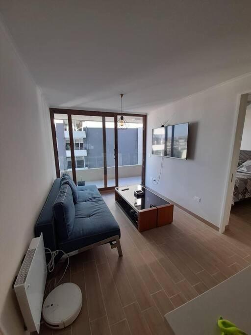 uma sala de estar com um sofá e uma televisão em Edifico claro solar piso 16 em Temuco