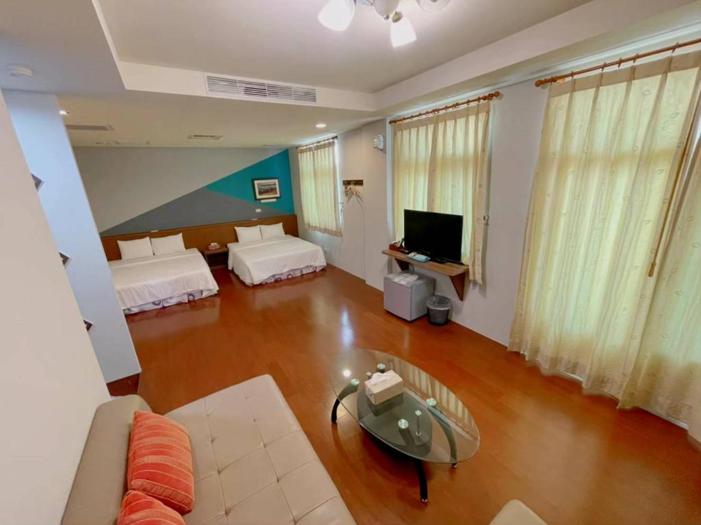 馬公市的住宿－居山水岸民宿，一间带两张床和一张沙发的客厅