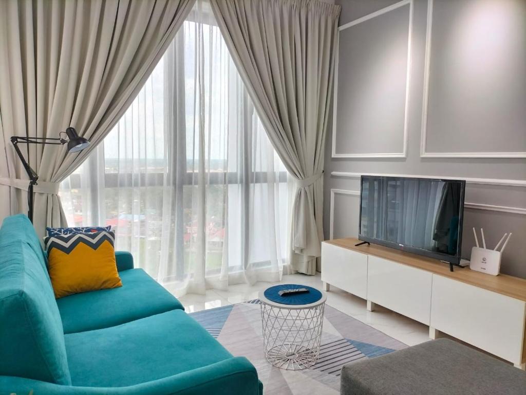 哥打巴魯的住宿－Zulanie Suite Troika Residence, SPACIOUS AND COZY WITH POOL, Free Wifi & Netflix in Golden Triangle of Kota Bharu，客厅配有蓝色的沙发和电视