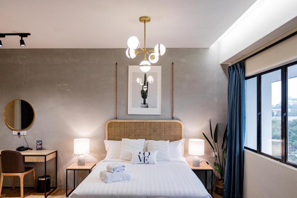 A styled bedroom with a double bed, desk and large window.