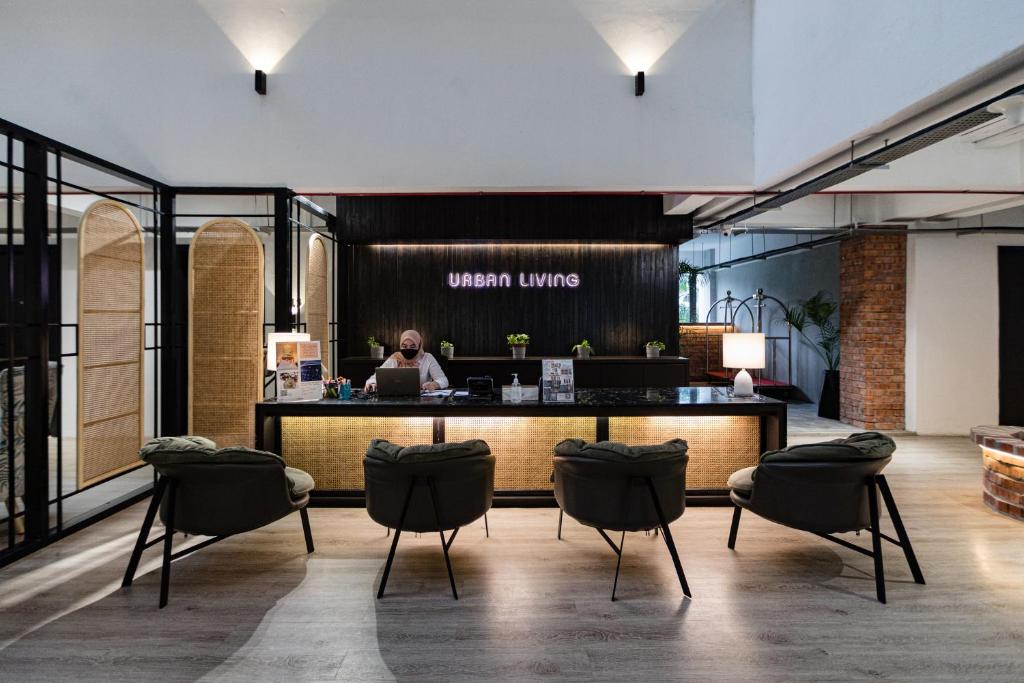 a lobby with a woman sitting at a counter at Urban Living Residence in Kuala Lumpur