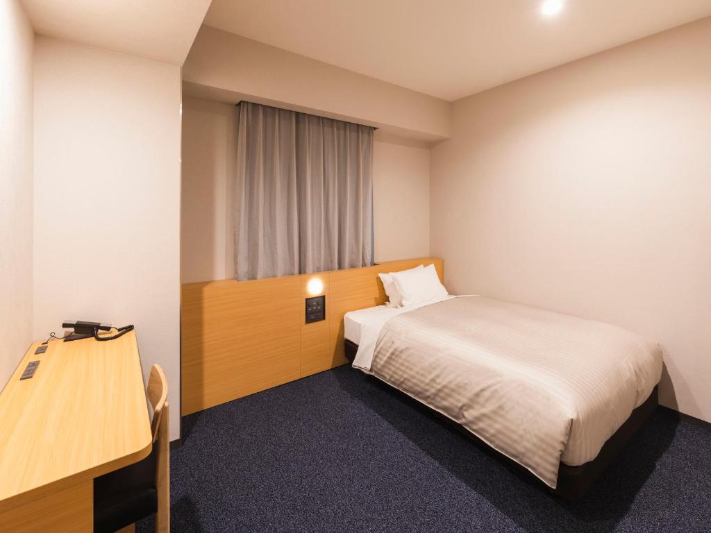 Postel nebo postele na pokoji v ubytování Sotetsu Fresa Inn Daimon