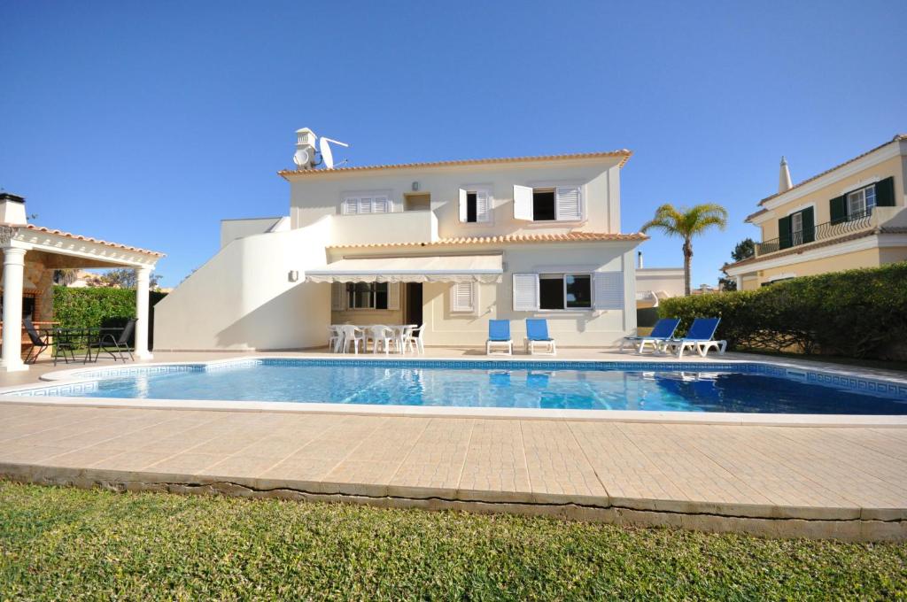 een villa met een zwembad voor een huis bij Large 6 bedroom private pool villa in Vilasol Resort in Quarteira
