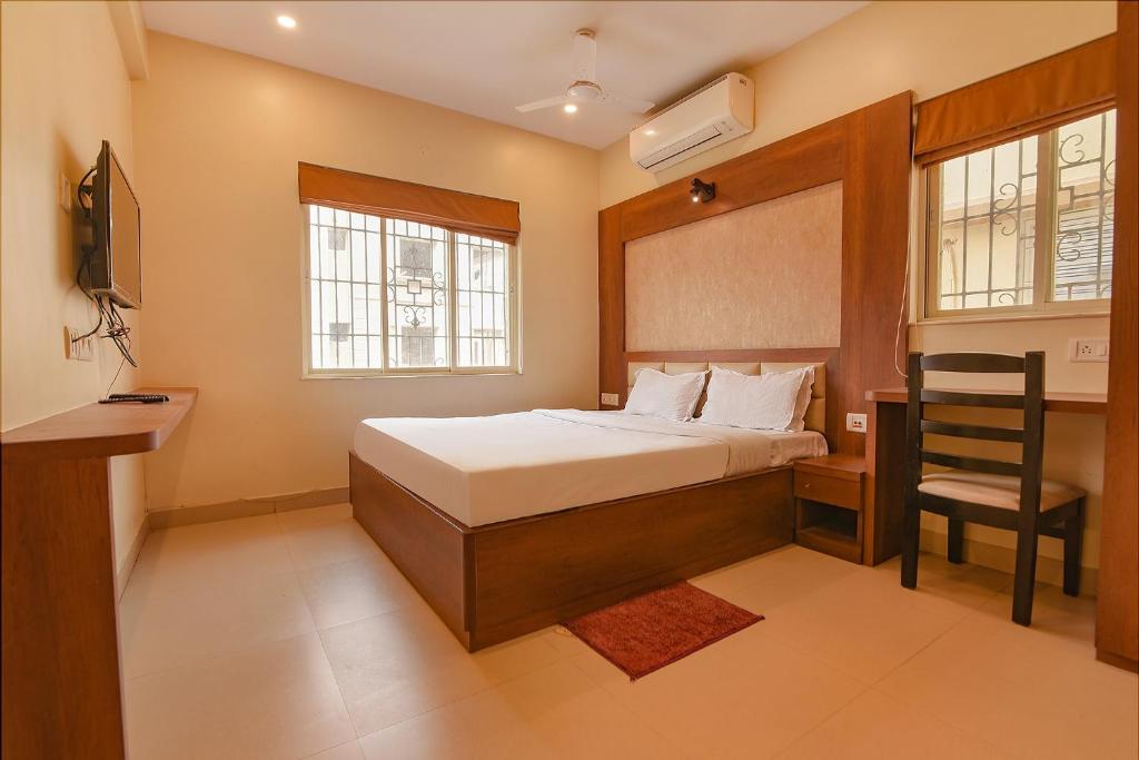 a bedroom with a bed and a chair in it at Via Dream Plaza - Nr Biswa Bangla Gate in Kolkata