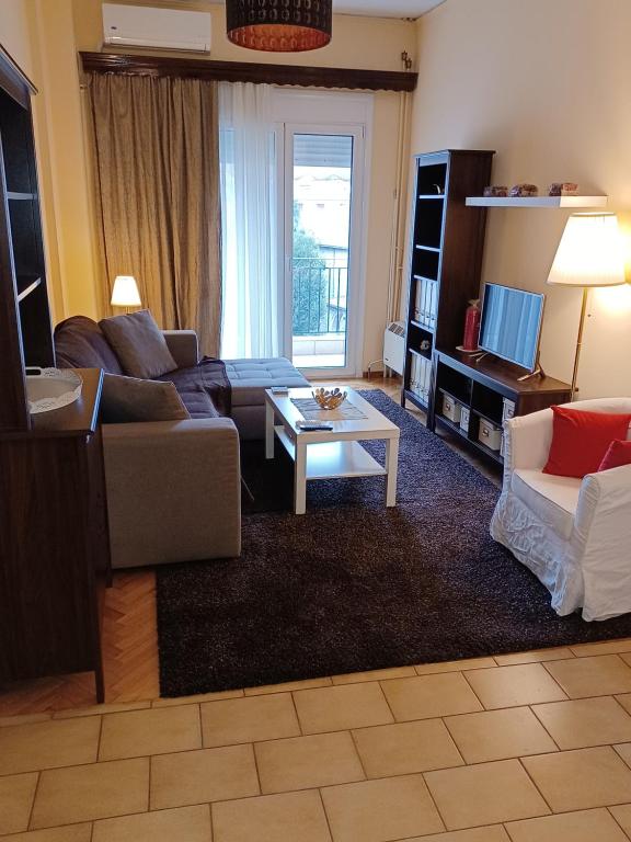 ein Wohnzimmer mit einem Sofa und einem Tisch in der Unterkunft Central Apartment Ioannina in Ioannina