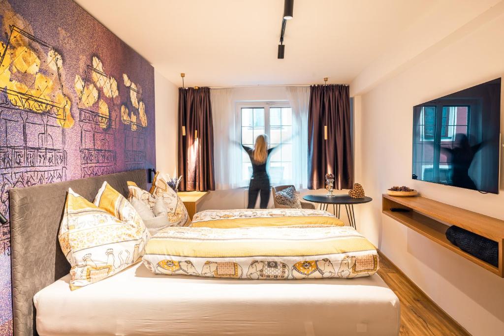 a woman is looking out the window of a hotel room at Hofgasse Apartments in Innsbruck