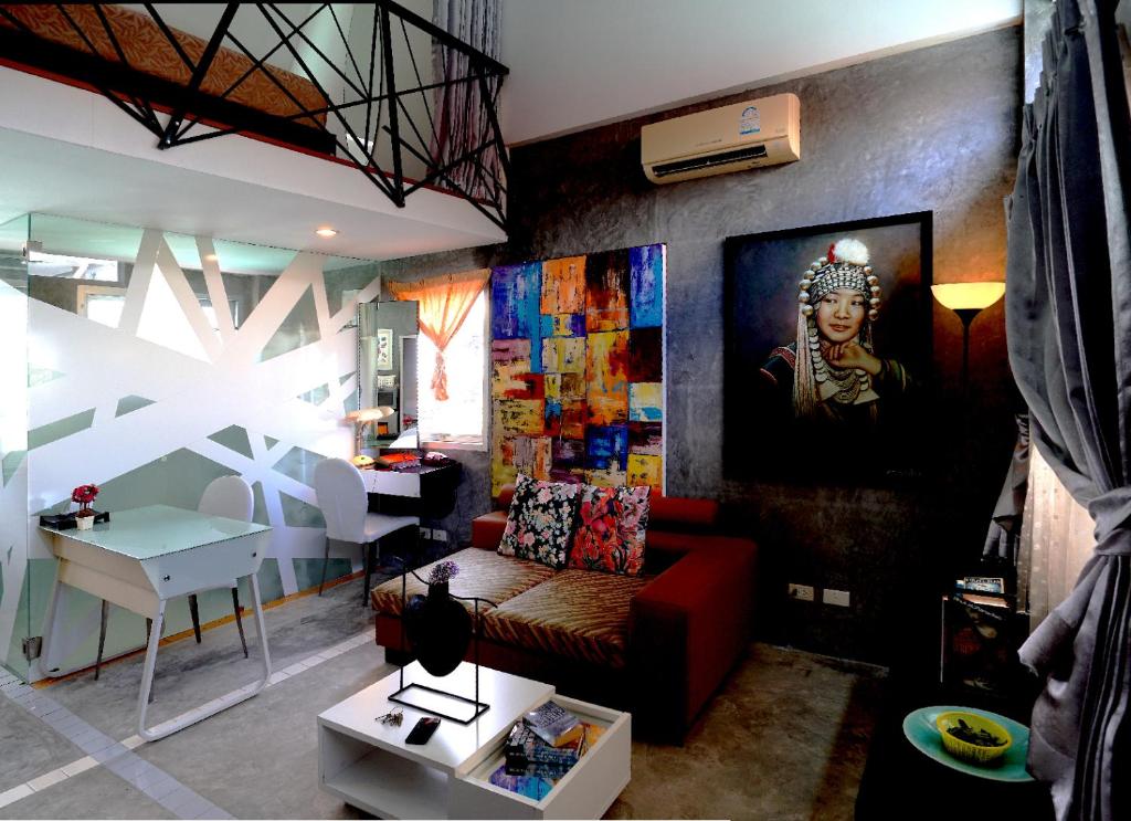 uma sala de estar com um sofá vermelho e uma pintura na parede em Phuket Paradiso em Chalong