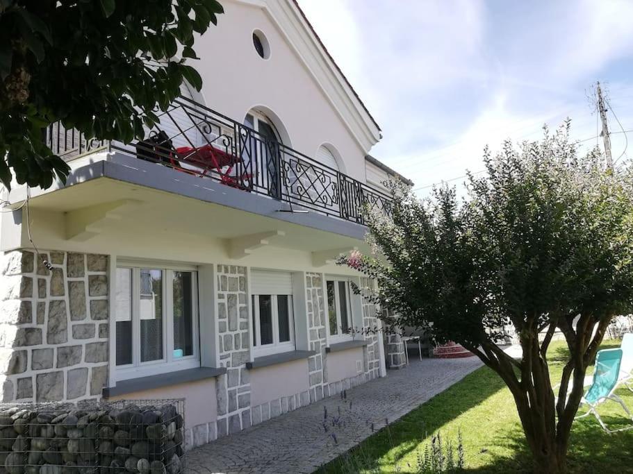 a white house with a balcony and a tree at Appartement dans Villa in Pau