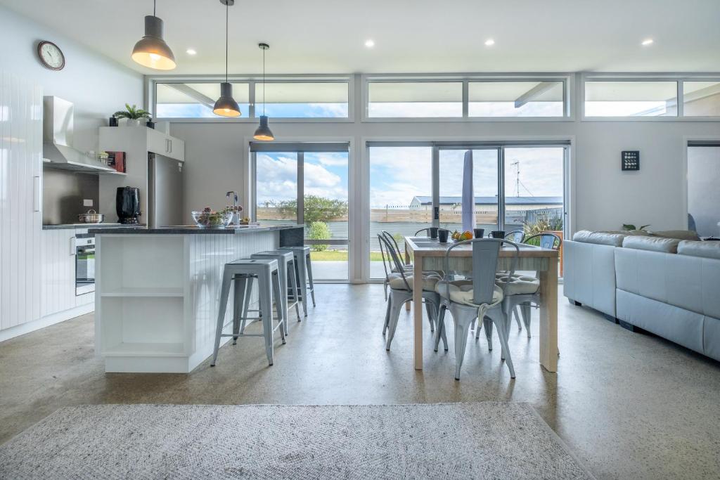 a kitchen and dining room with a table and chairs at Amaroo 1 - Freycinet Holiday Houses in Coles Bay