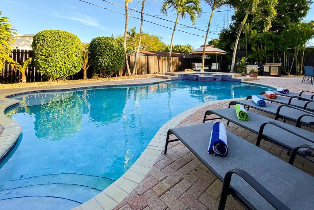 a large swimming pool with chairs and a table at 5BR! Pool, Air Hockey, Playground, Gazebo, BBQ, Sleeps 16 in Miami