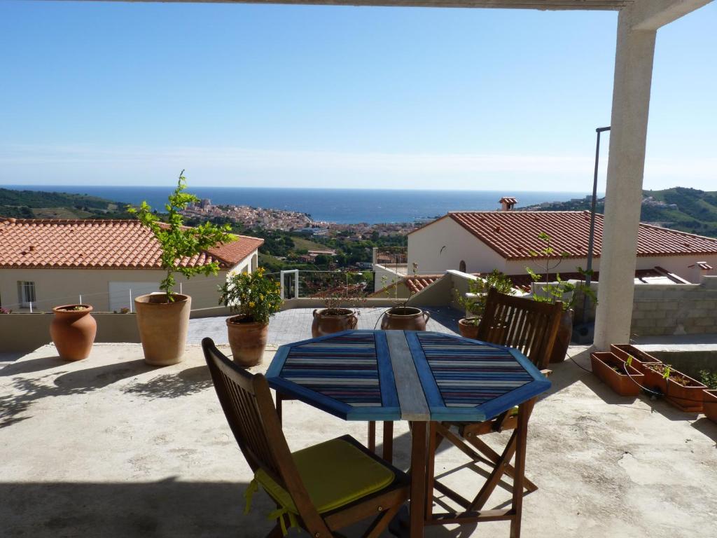 einen Tisch und Stühle auf einer Terrasse mit Meerblick in der Unterkunft la belle bleue in Banyuls-sur-Mer