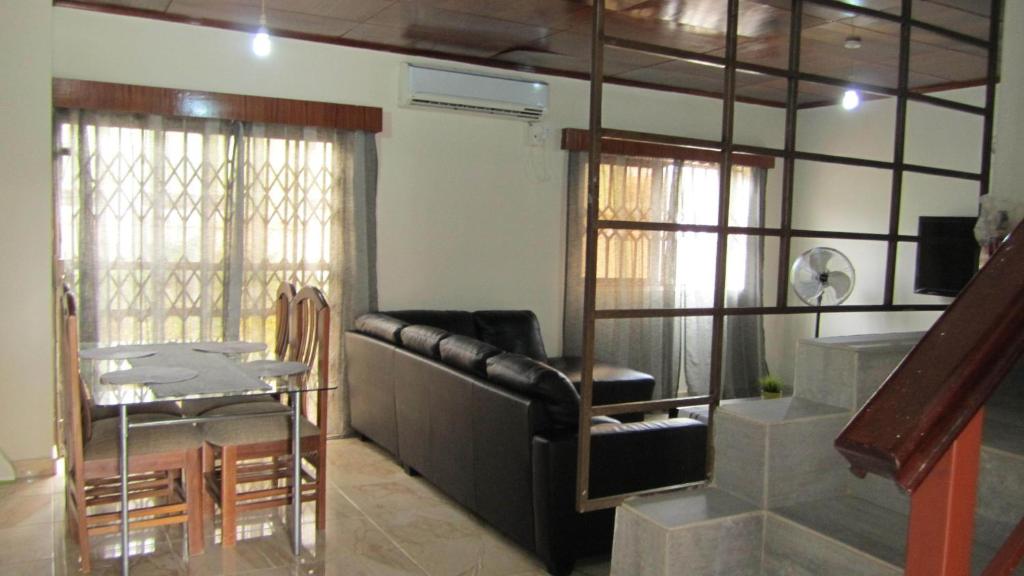 a living room with a leather couch and a table at Spintex Villas - Available for Long Term Rentals in Ablekuma