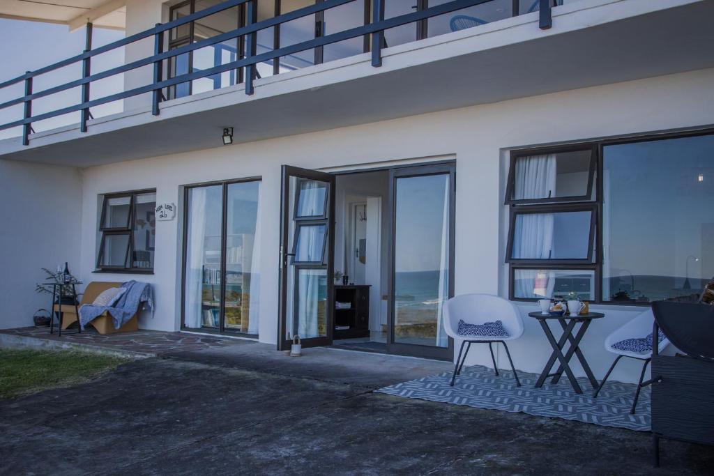 a white house with windows and a table and chairs at HIGH LEVEL 26 in Agulhas