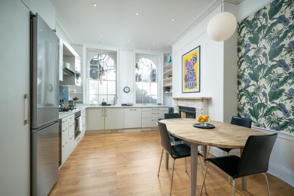 een keuken en eetkamer met een tafel en stoelen bij JOIVY Modern 4 bed flat with communal courtyard in Angel, East London in Londen
