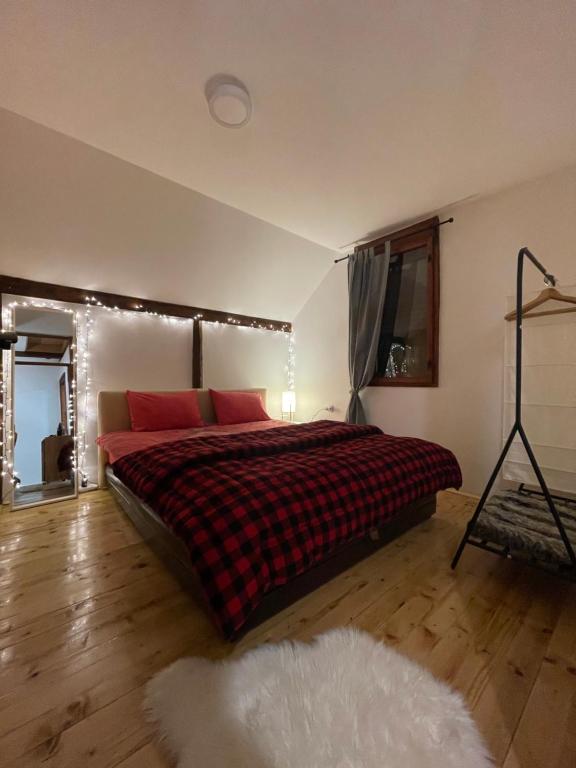 a bedroom with a large bed with red pillows at Cottage in the wild Pješčanica in Kolašin