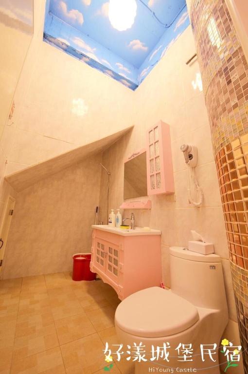a bathroom with a white toilet and a sink at Hi Young Castle in Hengchun South Gate