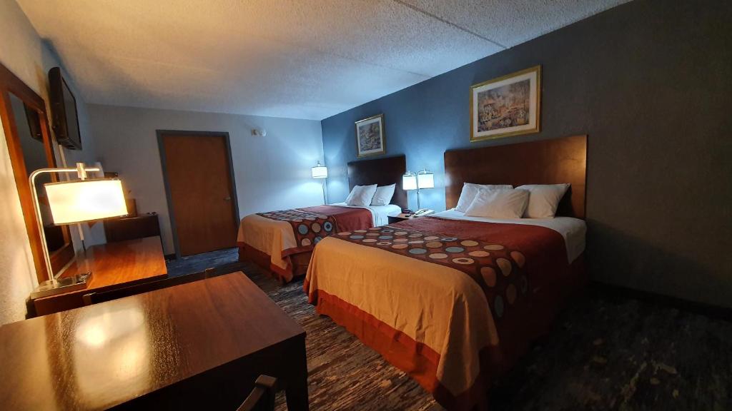 ein Hotelzimmer mit zwei Betten und einem Tisch in der Unterkunft South Padre Island Inn in South Padre Island