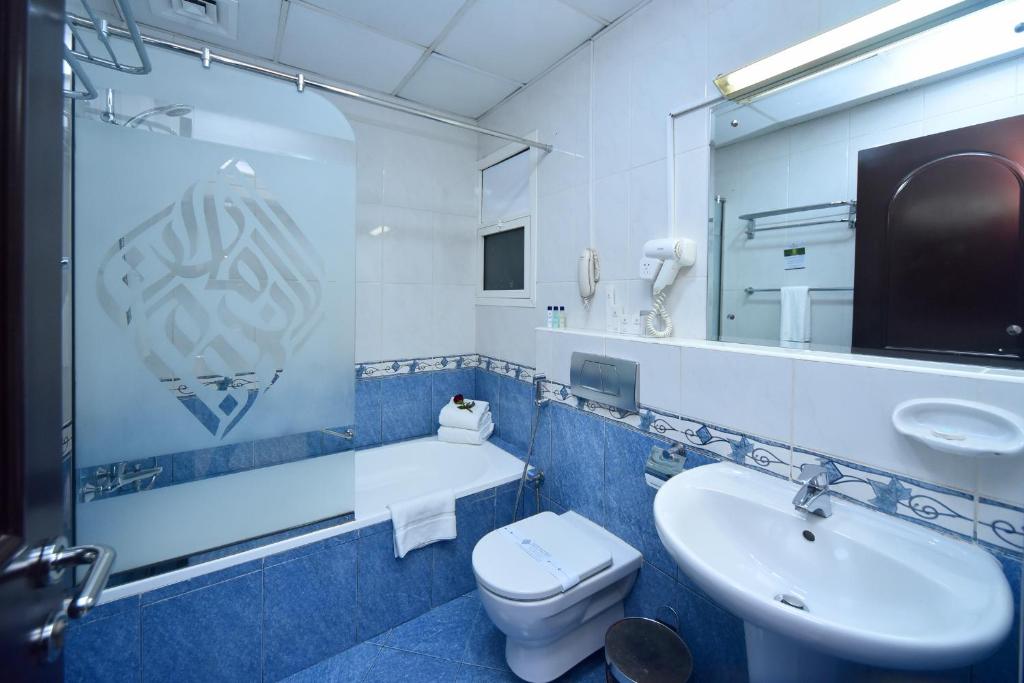 a bathroom with a sink and a toilet and a mirror at Emirates Stars Hotel Apartments Dubai in Dubai
