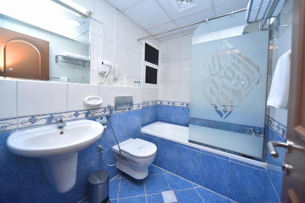 a blue and white bathroom with a toilet and a sink at Emirates Stars Hotel Apartments Dubai in Dubai