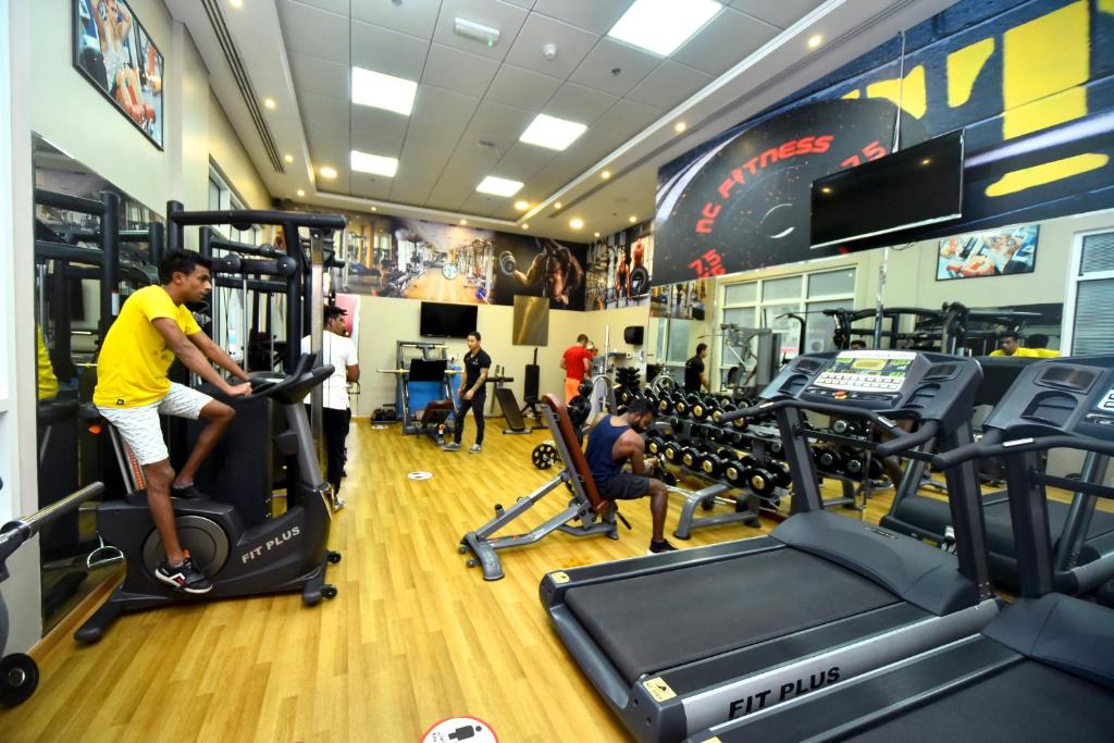 a man exercising on a treadmill in a gym at Emirates Stars Hotel Apartments Dubai in Dubai