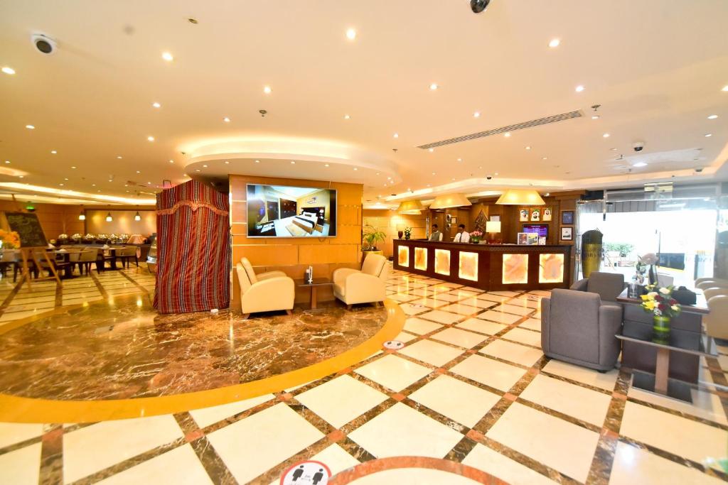 a hotel lobby with chairs and a bar at Emirates Stars Hotel Apartments Dubai in Dubai
